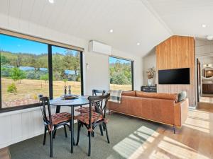 a living room with a couch and a table and chairs at Maydena Alpine Retreat in Maydena