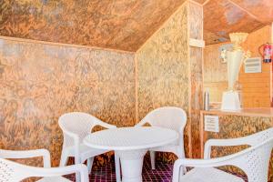 a table and chairs in a room with a wall at Collection O Foreshore Road Srinagar in Srinagar +22 photos