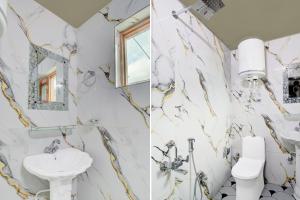 a bathroom with marble walls and a sink and a toilet at Collection O Foreshore Road Srinagar in Srinagar