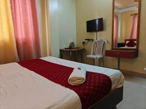 a hotel room with a bed and a mirror at Oasis Hotel and Restaurant in Siliguri