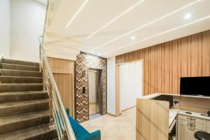 a lobby with a staircase and a television at Hotel O Mahakal Temple Formerly Shivangam in Ujjain