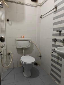 a bathroom with a toilet and a sink at Oasis Hotel and Restaurant in Siliguri +13 photos