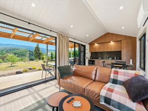 a living room with a couch and a kitchen at Maydena Alpine Retreat in Maydena