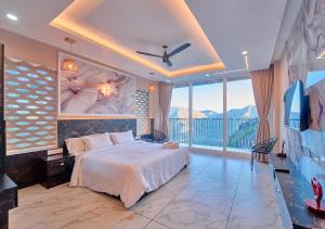a bedroom with a bed and a large window at Hill Breeze Pool Resort Vagamon by VOYE HOMES in Vagamon