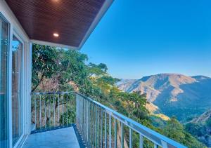 a balcony with a view of a mountain at Hill Breeze Pool Resort Vagamon by VOYE HOMES in Vagamon