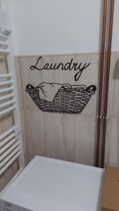 a bathroom with a sign that says laundry on the wall at Apartmani Bogatić 3 in Bogatić