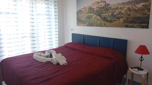 a red bed with two white towels on it at B&B Vista Mare in Belvedere Marittimo