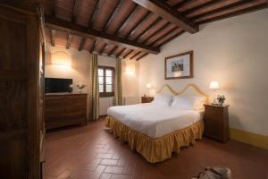 a bedroom with a large bed and a television at Relais Poggio Borgoni in San Casciano in Val di Pesa +75 photos
