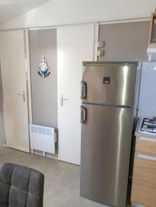a kitchen with a stainless steel refrigerator in a room at Mobile-Home L'Instant Marin in Sérignan