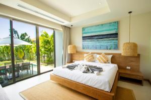 a bedroom with a bed with a view of the ocean at Villa 24 3BR Trichada Breeze in Phuket +44 photos