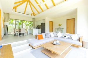 a living room with a white couch and a table at Villa 24 3BR Trichada Breeze in Phuket