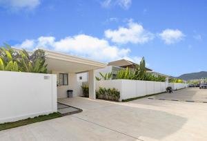 a white fence in front of a house at Villa 24 3BR Trichada Breeze in Phuket