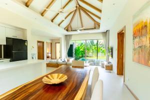 a kitchen and living room with a wooden table and chairs at Villa 24 3BR Trichada Breeze in Phuket
