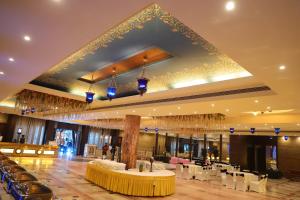 a banquet hall with tables and chairs and chandeliers at Grand Heritage Narmada Jacksons in Jabalpur