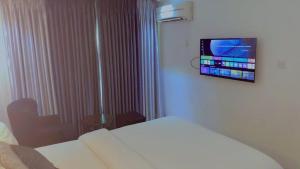 a hotel room with a bed and a tv on the wall at Brus View Suites in Ilado