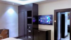 a room with a tv on the wall and a room with a room at Brus View Suites in Ilado