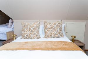 a bedroom with a white bed with pillows at Hoyozela in Hartbeespoort +17 photos