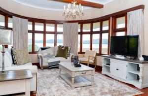 a living room with a tv and a large window at Hoyozela in Hartbeespoort