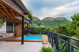 a house with a pool and mountains in the background at Hoyozela in Hartbeespoort