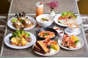 a table full of plates of food on a table at March Hotel & Suite Riverside in Chiang Mai