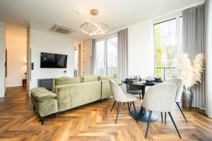 a living room with a couch and a table and chairs at Seaside Garden by Baltic Home Świnoujście in Świnoujście