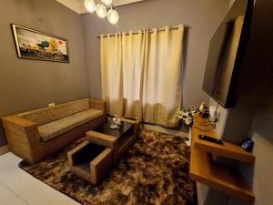 a living room with a couch and a television at Luxe Haven Homestay 2A in Guwahati