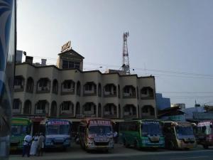 a group of buses parked in front of a building at Kdk lodge in Pollāchi