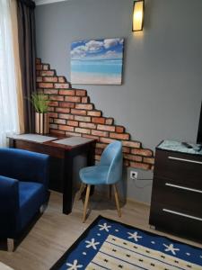 a living room with a blue chair and a table at Noclegi nad Morzem u Kasi in Gdańsk