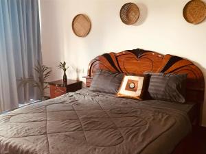 a bedroom with a large bed with a wooden headboard at Orchid bokor family guest house in Kampot +29 photos