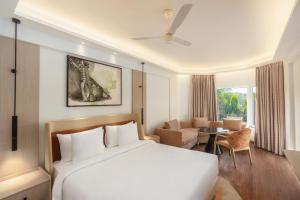 a bedroom with a bed and a living room at Hotel Gwalior Regency, a member of Radisson Individuals in Gwalior +49 photos