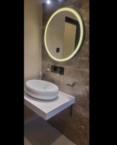 a bathroom with a white sink and a mirror at The Grandeur Suite 1 in Rawalpindi