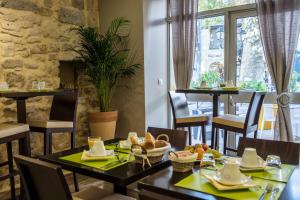 a restaurant with tables and chairs with food on them at Hôtel L'Herbier d'Orange - Accueil Vélo in Orange +38 photos