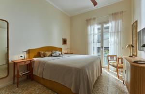 a bedroom with a bed and a dresser and a mirror at Vava Residence in Heraklio +32 photos
