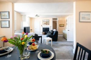 a living room with a table with a vase of flowers at Hill House Apartment in Framlingham