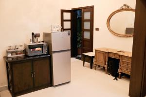 a kitchen with a refrigerator and a table and a mirror at The Grandeur Suite 1 in Rawalpindi