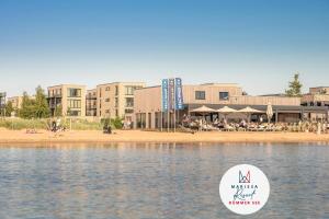 a body of water with buildings in the background at Marissa Resort in Lembruch