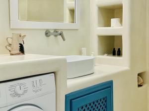 a bathroom with a sink and a washing machine at Tiara hideaway house in Éxo Goniá +13 photos