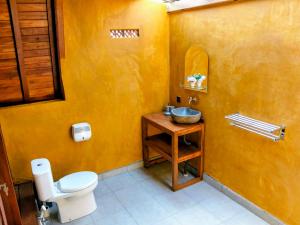 a bathroom with a white toilet and a sink at Pondok Kayu Canggu in Dalung