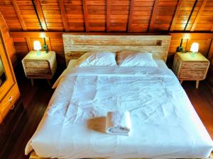a bedroom with a large white bed with two night stands at Pondok Kayu Canggu in Dalung