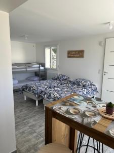 a room with two beds and a table in it at LAVANDE studio 4 personnes in Château-Arnoux-Saint-Auban