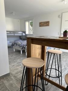 a kitchen and living room with a bar and stools at LAVANDE studio 4 personnes in Château-Arnoux-Saint-Auban