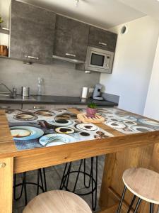 a kitchen with a counter top with a table with chairs at LAVANDE studio 4 personnes in Château-Arnoux-Saint-Auban +4 photos