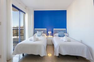two beds in a room with a blue wall at Ag Eden Resort in Gandía +238 photos