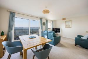 a living room with a table and chairs and a view at Island's Edge- Moments from Hamworthy Beach and Park in Poole