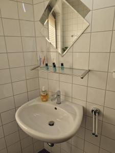 a white sink in a bathroom with a mirror at Hotel am Markt Eschweiler in Eschweiler +1 photo
