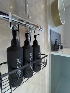 two black bottles on a shelf in a bathroom at St Michaels Reach Guest House in Marazion