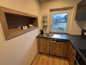 a small kitchen with a sink and a window at Ferienwohnung Grünblick am Katschbach in Teufenbach +10 photos