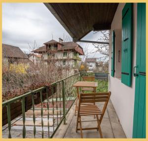 a balcony with two chairs and a table and a building at Maison Méserier I T3 I Publier in Publier