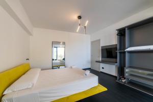 a bedroom with a white bed and a television at Dimora Eledia in Taormina
