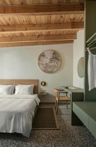 a bedroom with a bed and a desk and a table at FOS Luxury Suites in Nikiti +69 photos